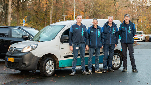 vier mannen van het fixteam staan voor een auto