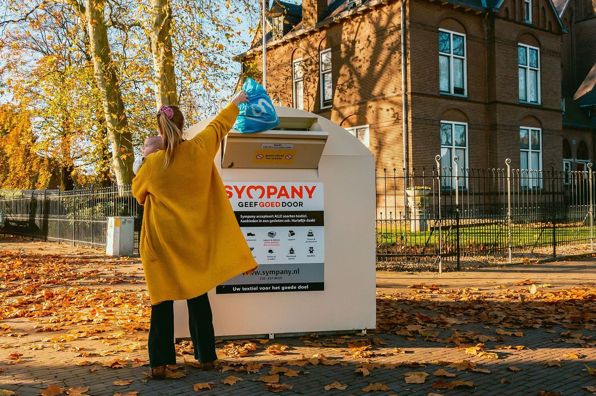 vrouw gooit vuilniszak in textielcontainer