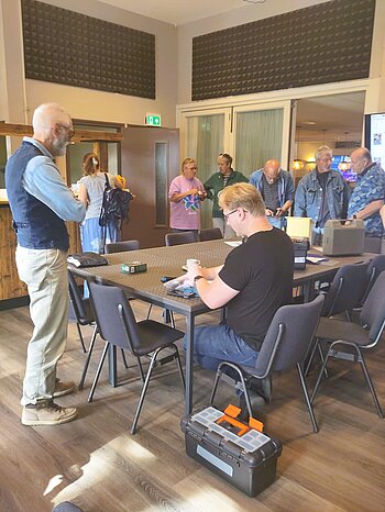 mensen staan en zitten rondom tafel