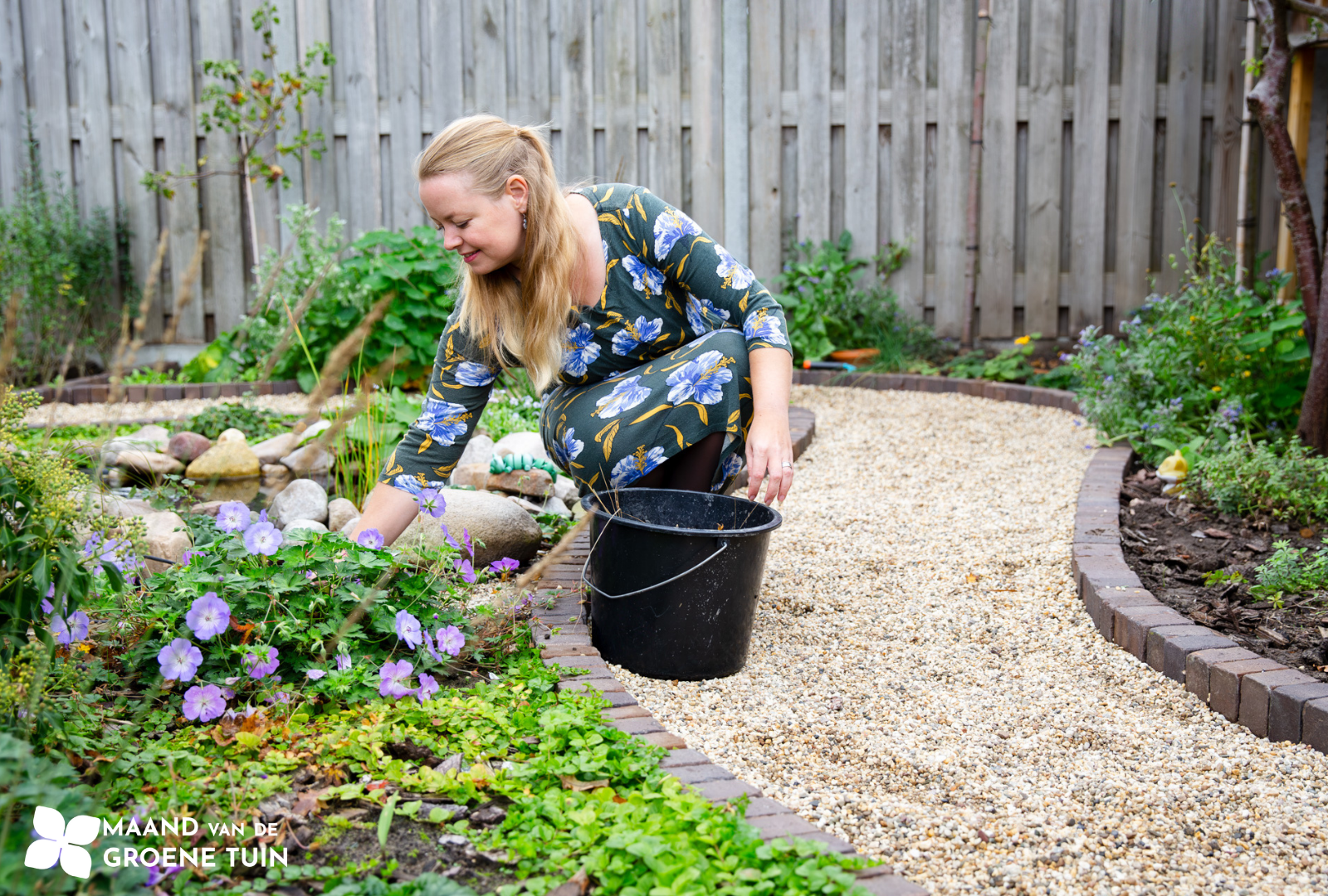 vrouw verzorgt planten in de tuin